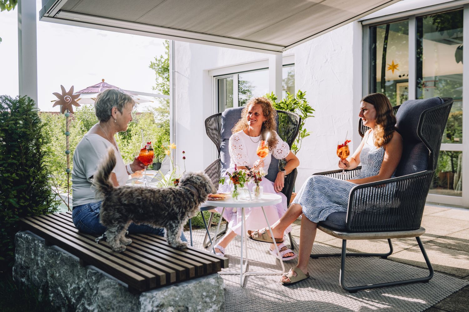 Drei Frauen trinken Aperol Spritz auf einer Terrasse