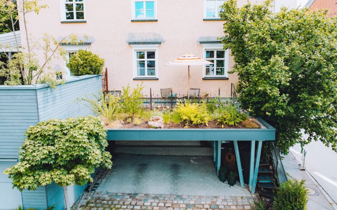 Der kleine Dachgarten in Stiefenhofen zeigt üppige Stauden, Kübelpflanzen und eine Terrasse über dem Carport.