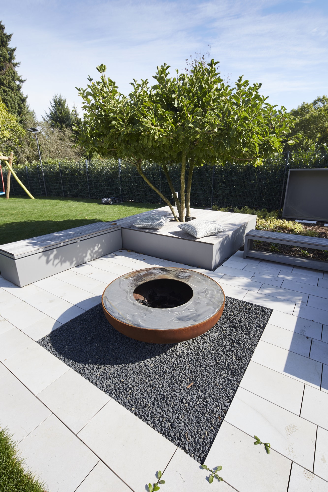 gartensilber_19FAUTZ9006 Holzklapptisch mit vier passenden Stühlen aus Holzlatten und schwarzen Metallrahmen, Gartenmöbel-Set auf gepflasterter Terrasse; rundes Laternenlicht im Hintergrund